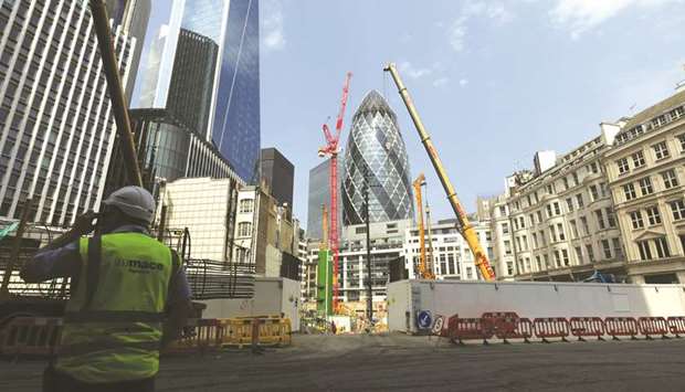 A construction worker stands outside a building site near 30 St Maryu2019s Axe in the City of London. u201cIt is clear that the UK is in the largest recession on record,u201d the Office for National Statistics said after gross domestic product contracted by 20.4% in the period from April to June.