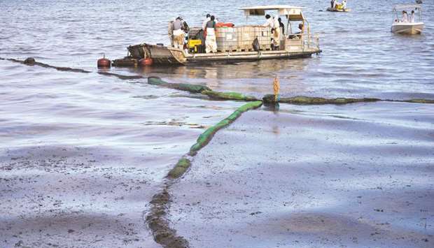 Volunteers attempt to clean spilled oil from the bulk carrier ship MV Wakashio, belonging to a Japanese company but Panamanian-flagged, that ran aground on a reef, at the Mahebourg Waterfront in Riviere des Creoles.