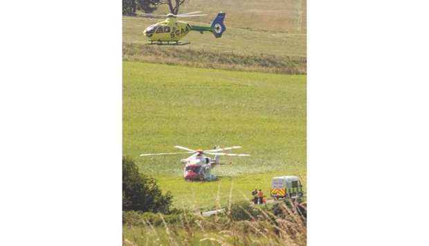 Helicopters and a police van stand near the scene of the train crash in Stonehaven in northeast Scotland, yesterday.