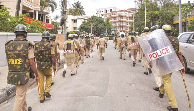 Police patrol a street after violence broke out overnight in Devara Jevana Halli area in Bengaluru, yesterday.