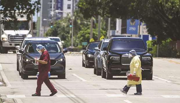 Medics cross the road outside Coral Gables Hospital where Coronavirus patients are treated near Miami on July 30. On Thursday, the US announced that its economy contracted at a 32.9% pace from April through June, one of the biggest drops on record.
