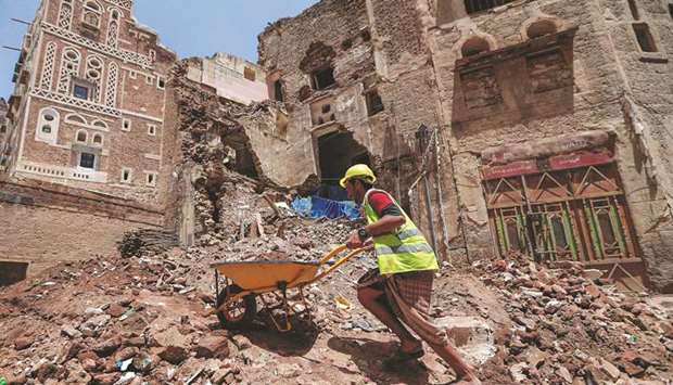 Yemeni labourers remove the rubble ahead of restoration works on the site of a collapsed Unesco-listed building following heavy rains, in the old city of the Yemeni capital Sanaa, yesterday.