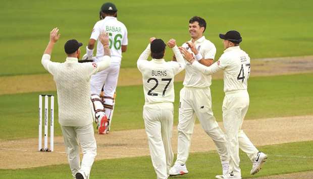 Englandu2019s James Anderson (second from right) celebrates with teammates after taking the wicket of Pakistanu2019s Babar Azam on the second day of the opening Test at Old Trafford in Manchester, United Kingdom, on August 6, 2020. (AFP)