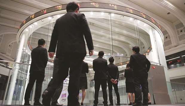 Visitors watch share prices at the Tokyo Stock Exchange. The Nikkei 225 closed up 1.8% to 23,249.61 points yesterday.