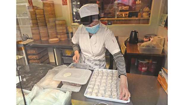 A cook makes dumplings for takeaway orders in the window of a restaurant in Melbourneu2019s Chinatown area yesterday.