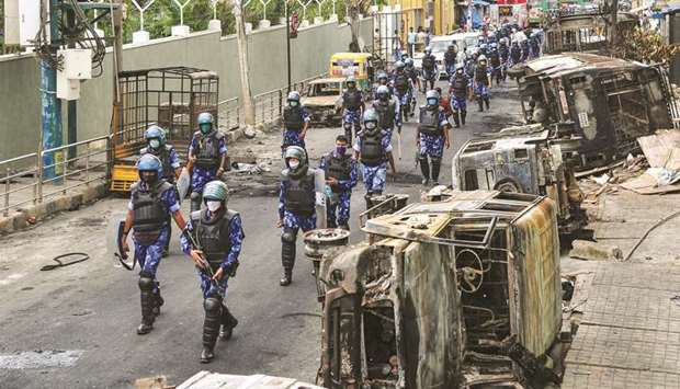 Rapid Action Force (RAF) personnel patrol on a street of DJ Halli in Bengaluru yesterday.