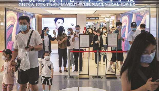 People show their health codes on their smartphones at the entrance of a mall in Beijing. Chinau2019s retail sales dropped in July, official data showed yesterday, indicating that sluggish consumer spending could hold up the countryu2019s recovery from the coronavirus outbreak.