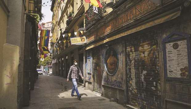 A pedestrian walks along a side street lined with shuttered restaurants in Madrid. CEOE, Spainu2019s main business lobby has warned that any second lockdown would have catastrophic consequences and urged the government to promote the use of a new app developed by the Economy Ministry to trace cases of Covid-19.