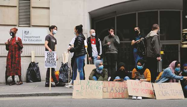 Students and other demonstrators hold placards as they protest outside the department for education in central London yesterday against the downgrading of A-level results.