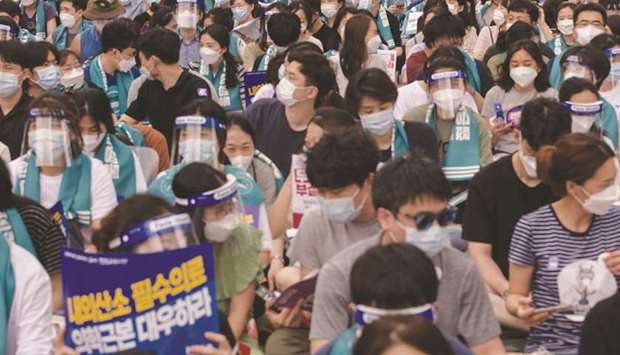 Doctors, medical students and healthcare professionals wearing face masks and protective equipment as part of preventative measures against the novel coronavirus attend a rally calling for the government to increase its annual intake of medical students, in the Yeouido district of Seoul yesterday.