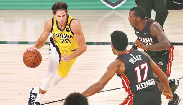 Indiana Pacers forward Doug McDermott (left) dribbles against Miami Heat guard Kendrick Nunn (right) and forward Kyle Alexander during their NBA game at AdventHealth Arena in Lake Buena Vista, Florida, United States, on Friday. (USA TODAY Sports)
