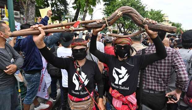 Anti-government protesters carry a wooden yoke, used to tie buffalo or oxen during ploughing season, at a pro-democracy protest in Bangkok