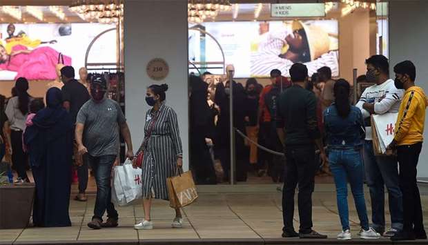 People wearing facemasks shop at the Palladium Mall in Mumbai on Sunday.rnrn