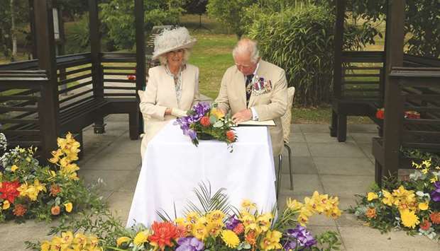 Prince Charles and Camilla, Duchess of Cornwall, sign the visitorsu2019 book during the VJ Day National Remembrance event, held at the National Memorial Arboretum in Staffordshire, Britain.