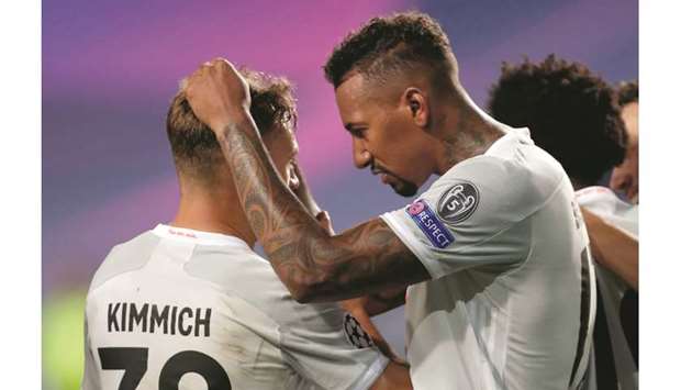 Bayern Munichu2019s Joshua Kimmich celebrates scoring their fifth goal with Jerome Boateng during their Champions League quarter-final against Barcelona in Lisbon on August 14, 2020. (Reuters)