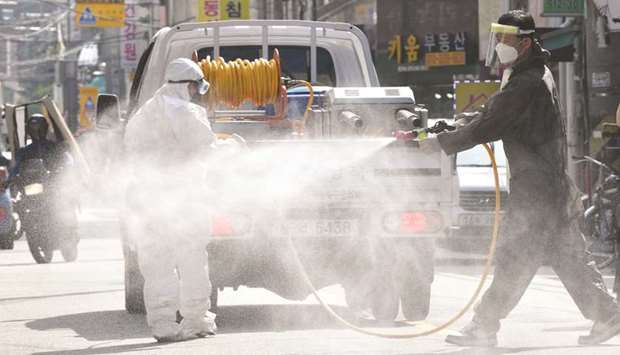 A health official wearing protective gear sprays disinfectant on the street near the Sarang Jeil Church, a new coronavirus infection cluster, in Seoul yesterday.
