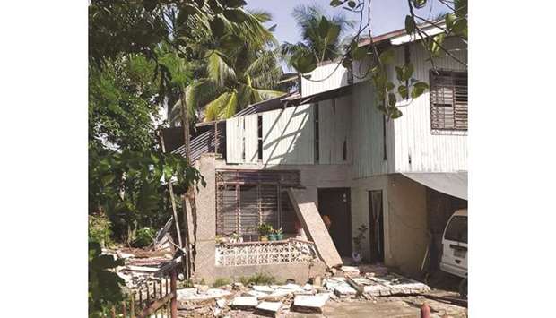 A partially damaged house is seen amid debris in Masbate Province, after an earthquake struck the Philippines yesterday.