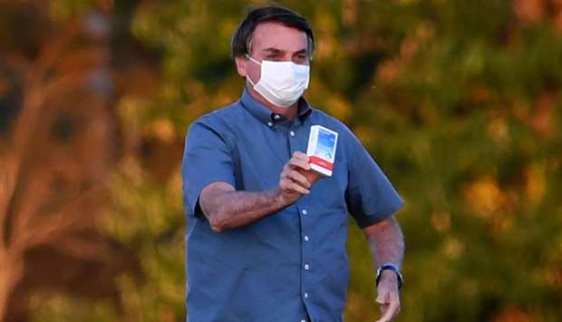 Brazilian President Jair Bolsonaro shows a box of hydroxychloroquine to supporters outside the Alvorada Palace in Brasilia on July 23.