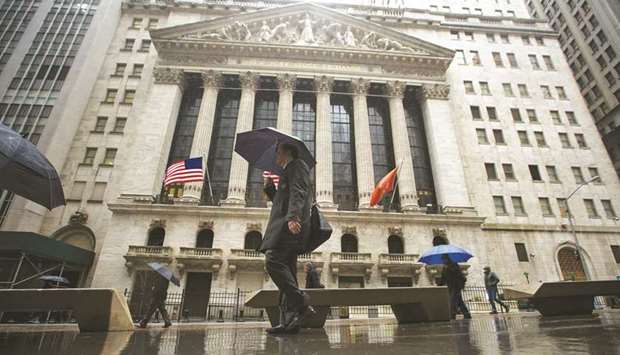 Pedestrians walk past the New York Stock Exchange. Some of the biggest money managers are vexed by the same paradox troubling everyone else: US stocks are near an all-time high, but the world still seems to be falling apart.
