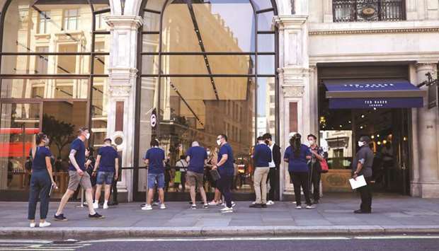 Employees of Apple serve customers as they stand in line outside the companyu2019s store on Regent Street in London. The unexpectedly robust retail sales figures showed the strength of consumer demand in the UK even as other parts of the economy are struggling to recover from recent hefty losses.