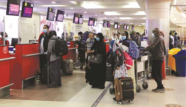 Passengers queue at the check-in counter as the Jomo Kenyatta international airport reopens after flights were suspended following the coronavirus disease (Covid-19) outbreak in Nairobi, yesterday.