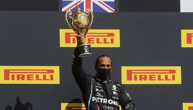 Mercedes' Lewis Hamilton celebrates winning the race on the podium with the trophy