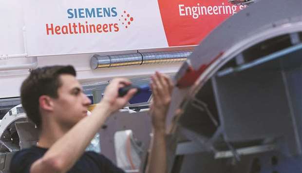 An employee works on the gantry of a Siemens Somatom computerised tomography (CT) scanner machine on the assembly line at the Siemens Healthineers factory in Forchheim, Germany. The medical technology company offered $177.5 a share for the Palo Alto, California-based Varian Medical Systems, 24% more than its closing price on Friday.