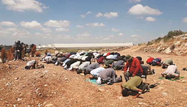 Palestinian demonstrators perform Friday prayers during a protest against Jewish settlements, near Tulkarm in the Israeli-occupied West Bank yesterday.