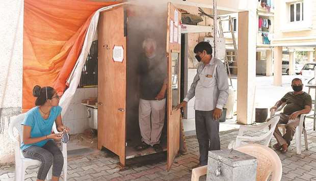 A man leaves a wooden booth after inhaling eco-friendly steam used as a preventive measure against the Covid-19 in Ahmedabad yesterday.