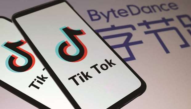 TikTok logos are seen on smartphones in front of a displayed ByteDance logo.