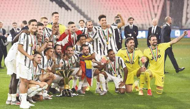 Juventus players celebrate with the trophy after winning the Serie A at an empty Allianz Stadium in Turin, Italy, on Saturday night. (Reuters)