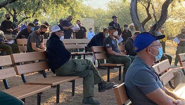 BRIEFING: Firefighters wear face masks at a morning briefing on the Bighorn Fire, north of Tucson, Arizona. Covid-prevention protocols u2014 based on guidelines from the Centers for Disease Control and Prevention u2014 are recommended for wildfire camps.