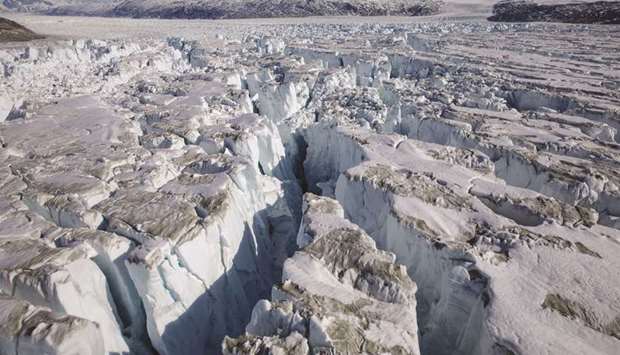 FILE PHOTO: Crevasses form on top of the Helheim glacier near Tasiilaq, Greenland, June 19, 2018. Given that the effects of climate change are already being felt around the world, countries urgently need to scale up their investments in climate adaptation and mitigation.