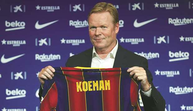 Barcelona coach Ronald Koeman poses with a team shirt during his unveiling at Camp Nou on Wednesday. (Reuters)