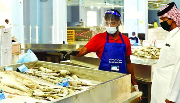 A salesman interacts with a customer at the new fish market at Umm Slal Central Market.