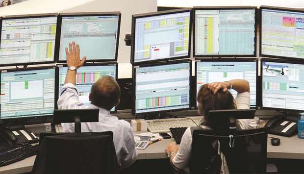 Traders work at the Frankfurt Stock Exchange. The DAX 30 closed up 1.0% to 13,190.15 points yesterday.