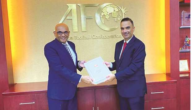 Qataru2019s ambassador to Malaysia Fahd bin Mohamed Kafood (right) presents the nationu2019s bid file for 2027 Asian Cup to AFC Secretary-General Windsor John in Kuala Lumpur.