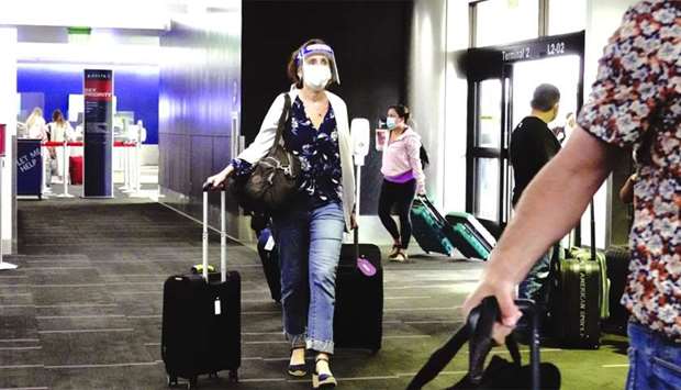 A traveller wearing a protective mask and face shield walks into Terminal 2 at Los Angeles International Airport. Airlines highlight the need to wear a face covering during the booking process, at check-in, at the gate and in onboard announcements. Failure to comply means that a passenger faces the risk of being offloaded from their flight, restrictions on future carriage or penalties under national laws.