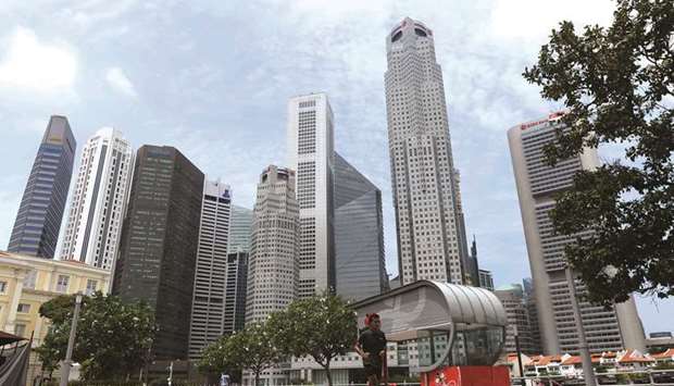 A man jogs along the Singapore River as the financial business district is seen in the background. The city is facing the worst recession in its history, forcing a rethink for some firms on expansion and hiring plans.