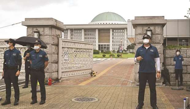 Police officers stand guard at the main gate of the National Assembly in Seoul yesterday. South Koreau2019s parliament was shut down yesterday and a group of lawmakers were in self-quarantine as the country recorded more than 400 new coronavirus infections.