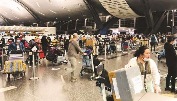 Filipino expatriates queue up for the repatriation flight at Doha's Hamad International Airport on Friday.