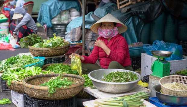 A woman wearing a protective mask sells vegetables during the coronavirus disease outbreak in Hoi An tourism town, Vietnam, July 31.