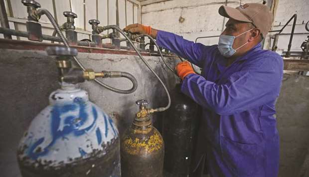 File photo shows a mask-clad worker refilling oxygen cylinders at a factory in Taji district, north of Iraqu2019s capital Baghdad, before delivering them to hospitals amid the Covid-19 pandemic on July 5, 2020.