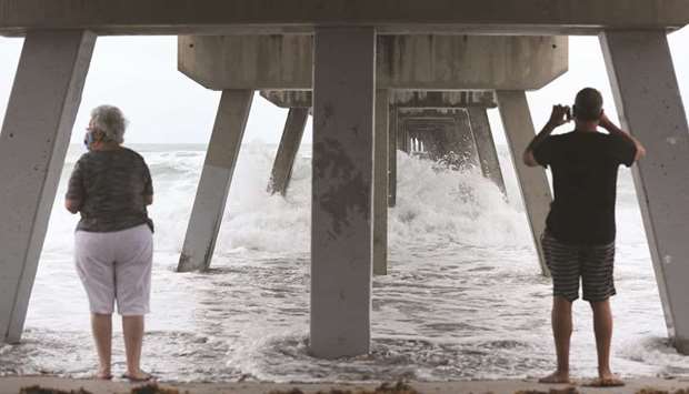 Residents watch the waves kicked up by Tropical Storm Isaias along the Deerfield Beach International Fishing Pier, in Florida.