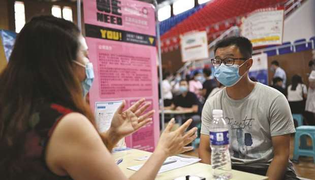 A job seeker (right) speaking with a recruiter of a company during a career fair in Zhengzhou, Chinau2019s Henan province.