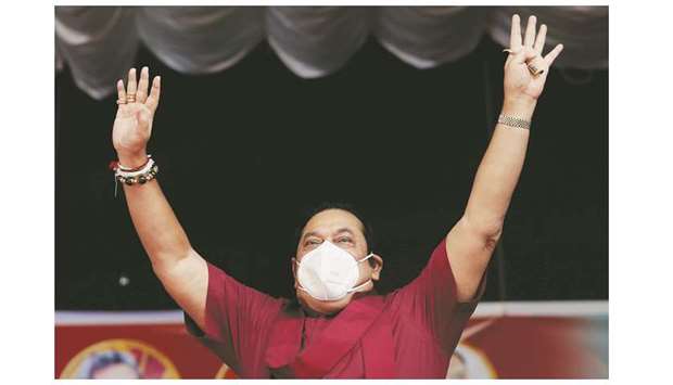 Sri Lankau2019s PM and leader of Sri Lanka Peopleu2019s Front party Mahinda Rajapaksa wearing a protective mask, waves at his supporters during a campaign rally ahead of August 5 parliamentary elections, in Ahungalla, Sri Lanka.