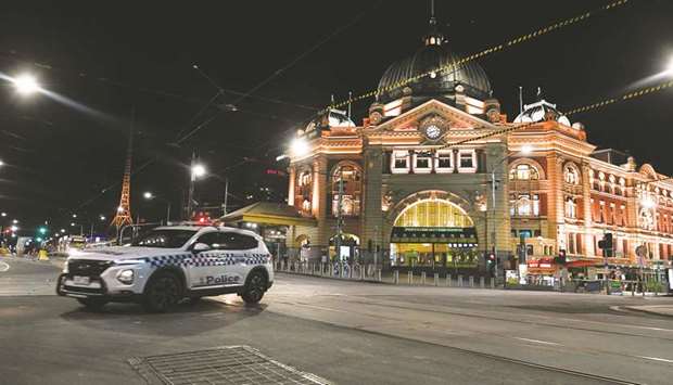 A police car is seen outside Flinders Street Station after a citywide curfew was introduced.