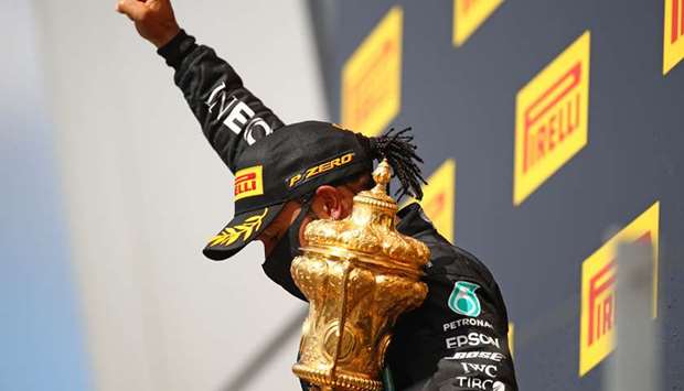 Mercedesu2019 British driver Lewis Hamilton gestures on the winnersu2019 podium after winning the Formula One British Grand Prix at the Silverstone motor racing circuit in central England on Sunday.