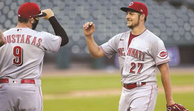 Trevor Bauer (right) of the Cincinnati Reds smiles as he is greeted by Mike Moustakas after their win over Detroit Tigers in game two of a doubleheader in Detroit, Michigan, on Sunday. (Getty Images/AFP)