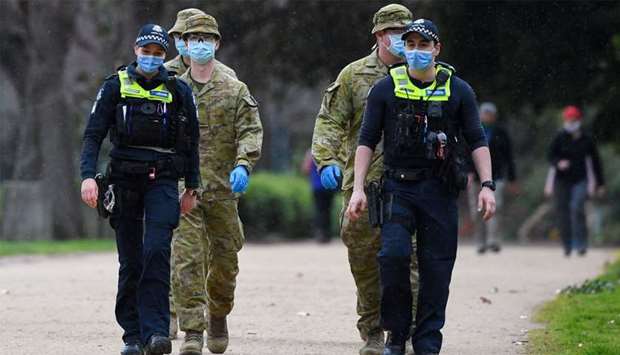 Police officers and soldiers patrol a popular running track in Melbourne
